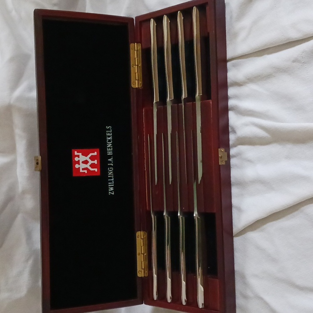Set of 8 Henckels steak knives in cherry stained wooden case.